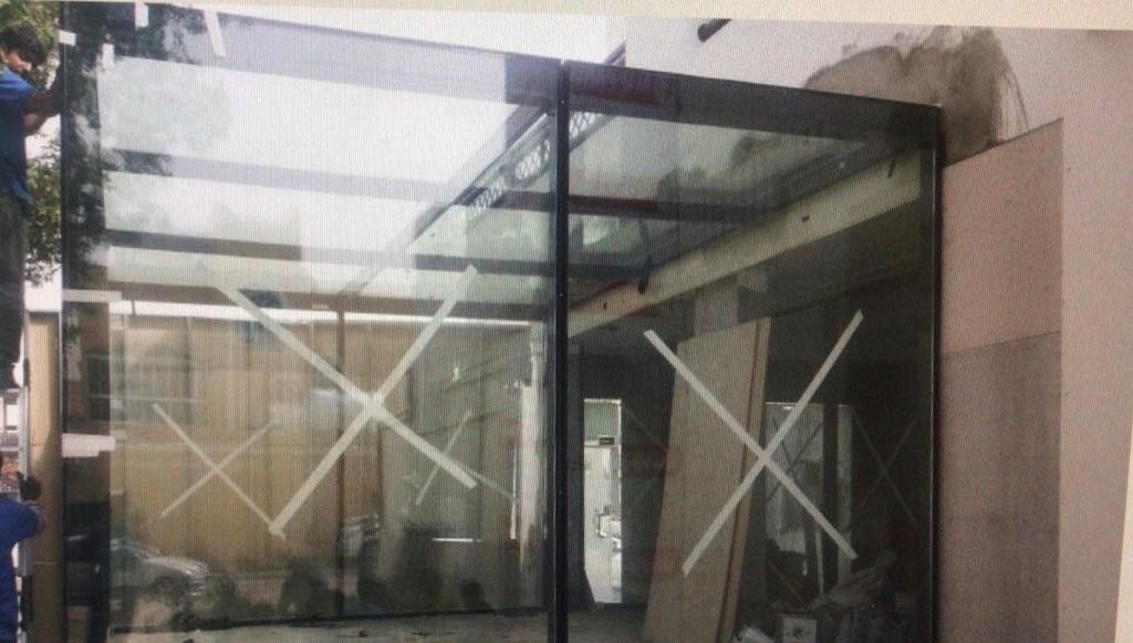 Newly installed glass shopfront panels taped and protected on site