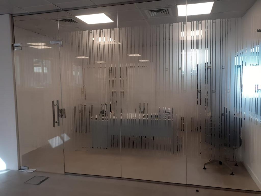Office glass partition with frosted stripe film and a swing glass door