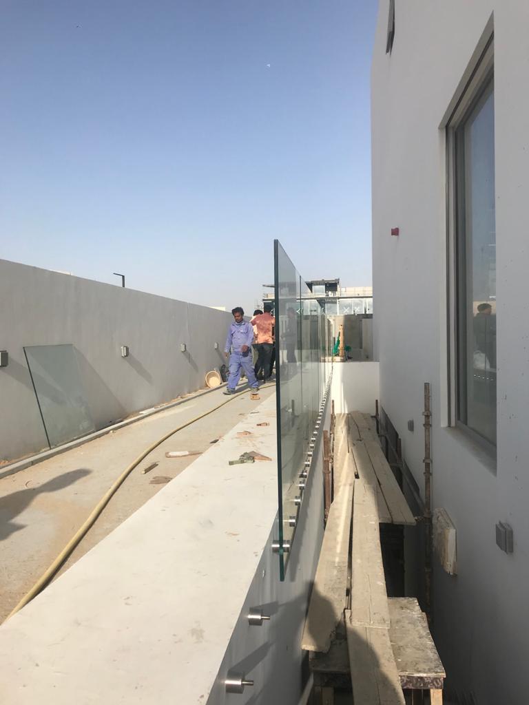 Frameless glass balustrade being installed along a rooftop terrace edge