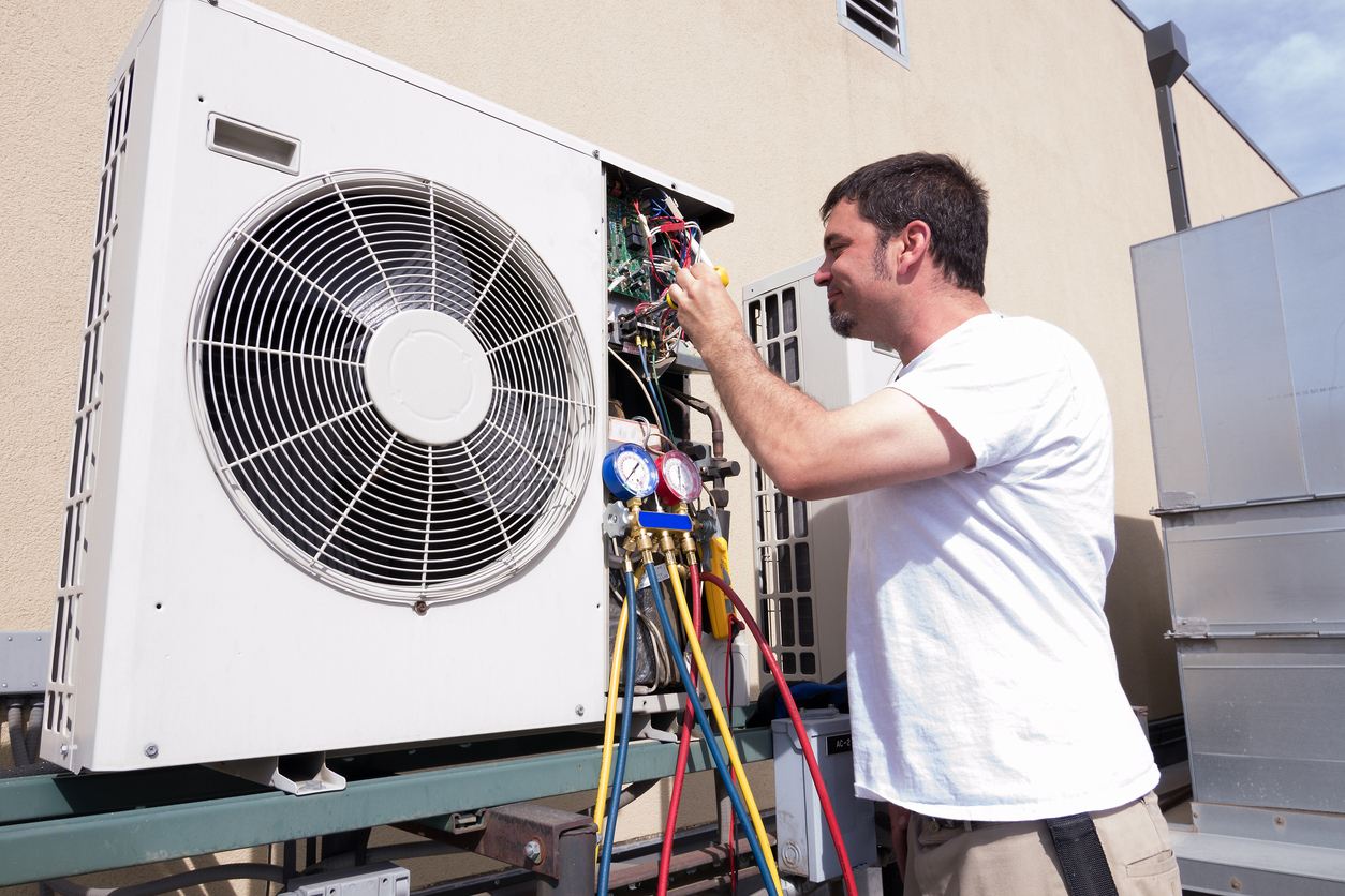Our technician checking refrigerant pressure with manifold gauges during a gas refill