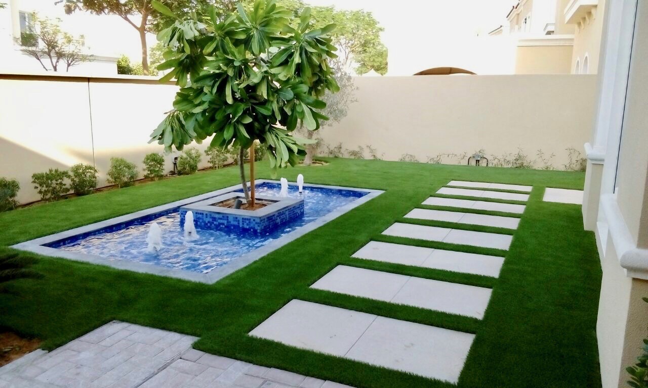 Artificial grass lawn we installed with water feature and stepping stones